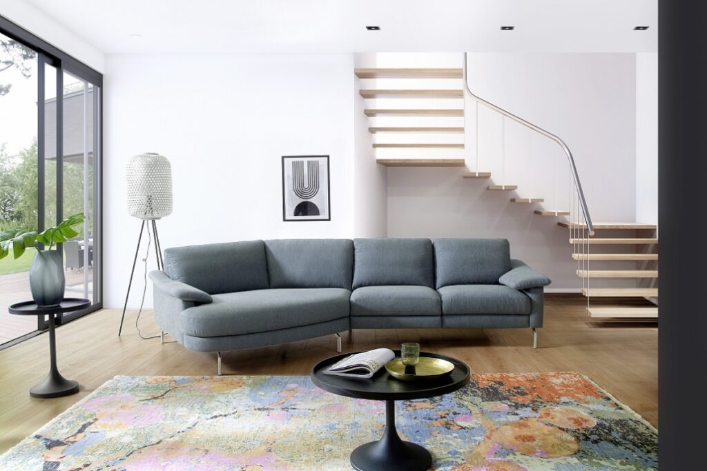 Bionda Kuschelelement, graues Stoffsofa mit geschwungener Form und Metallfüßen.