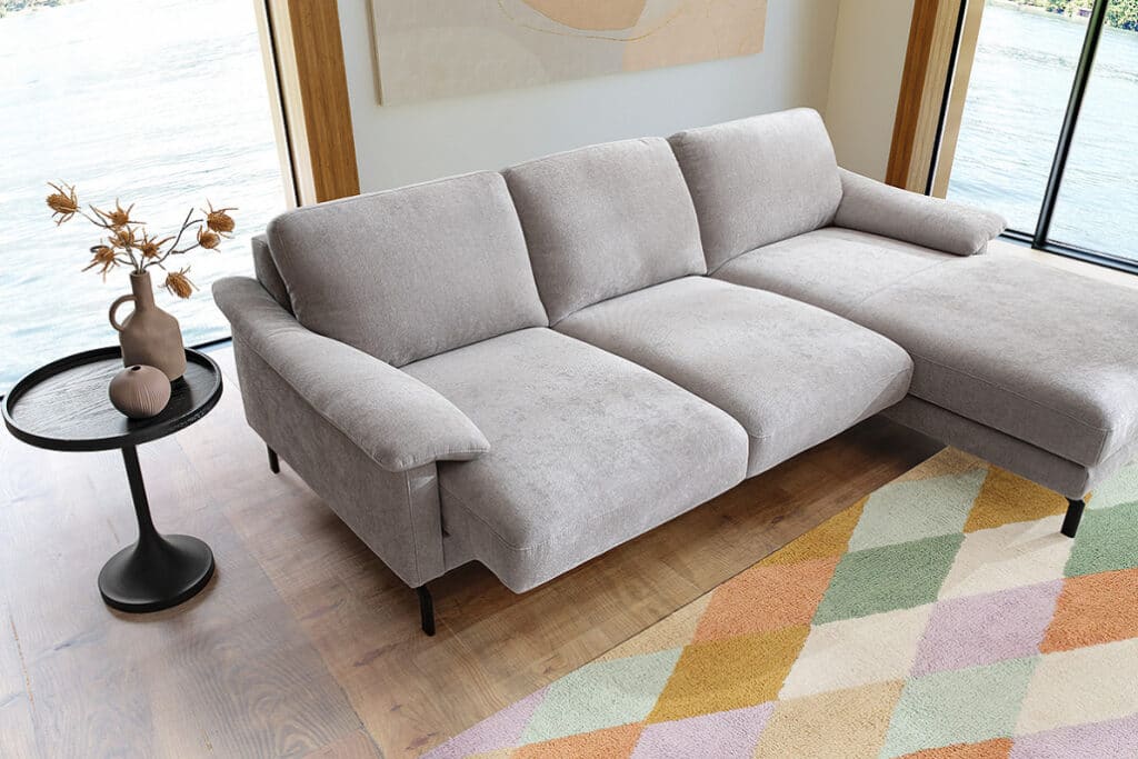 Bionda Sofa mit motorischem Sitzauszug in grauer Stoffausführung.