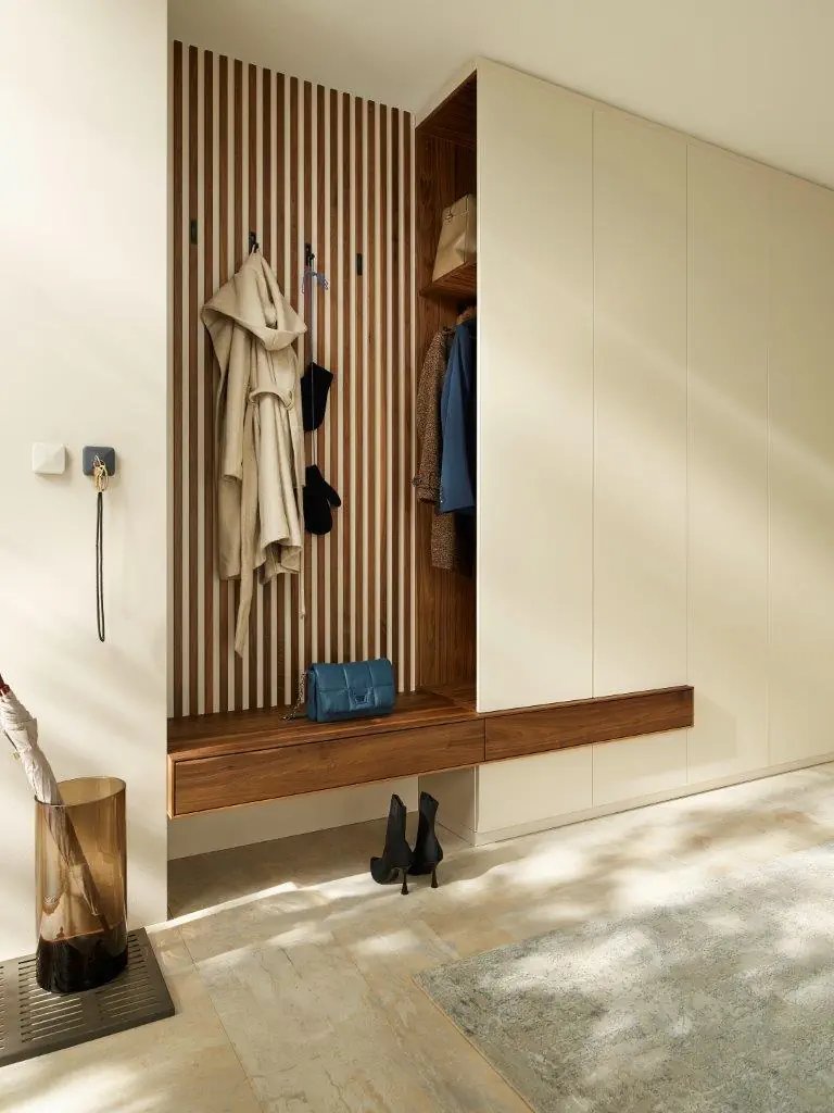 Anrei Garderobe Milieu 3 mit Holzpaneelen und integrierter Sitzbank.