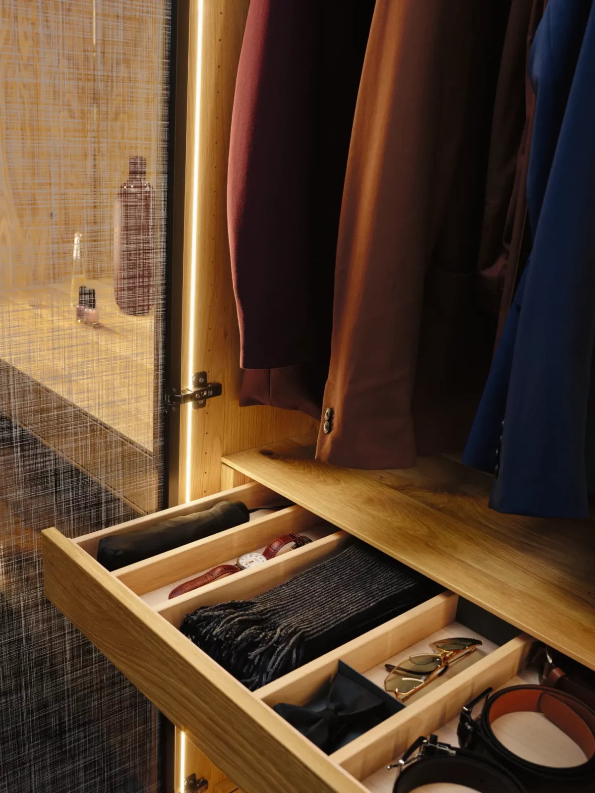Anrei Ruum Kleiderschrank aus Holz mit Lichtband und geöffneter Schublade.