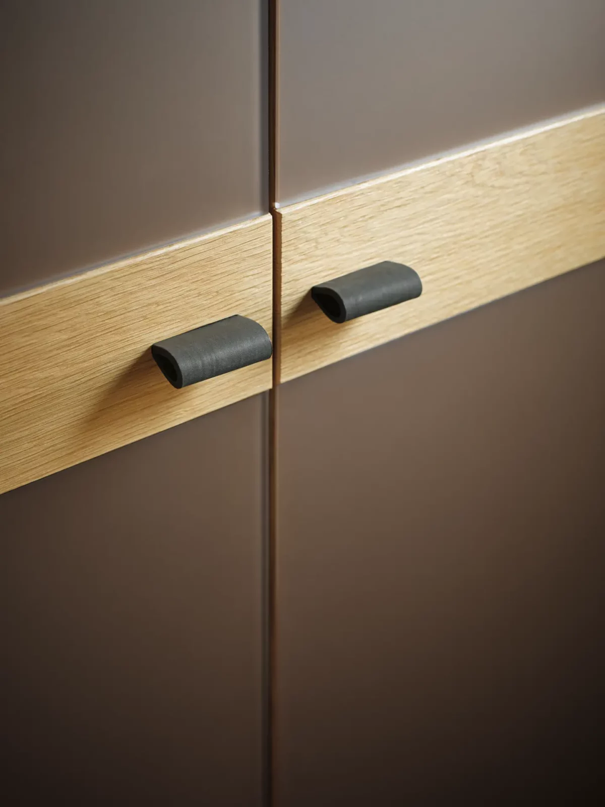 Anrei Ruum Schrank mit Eichenholzleiste und schwarzen Ledergriffen.