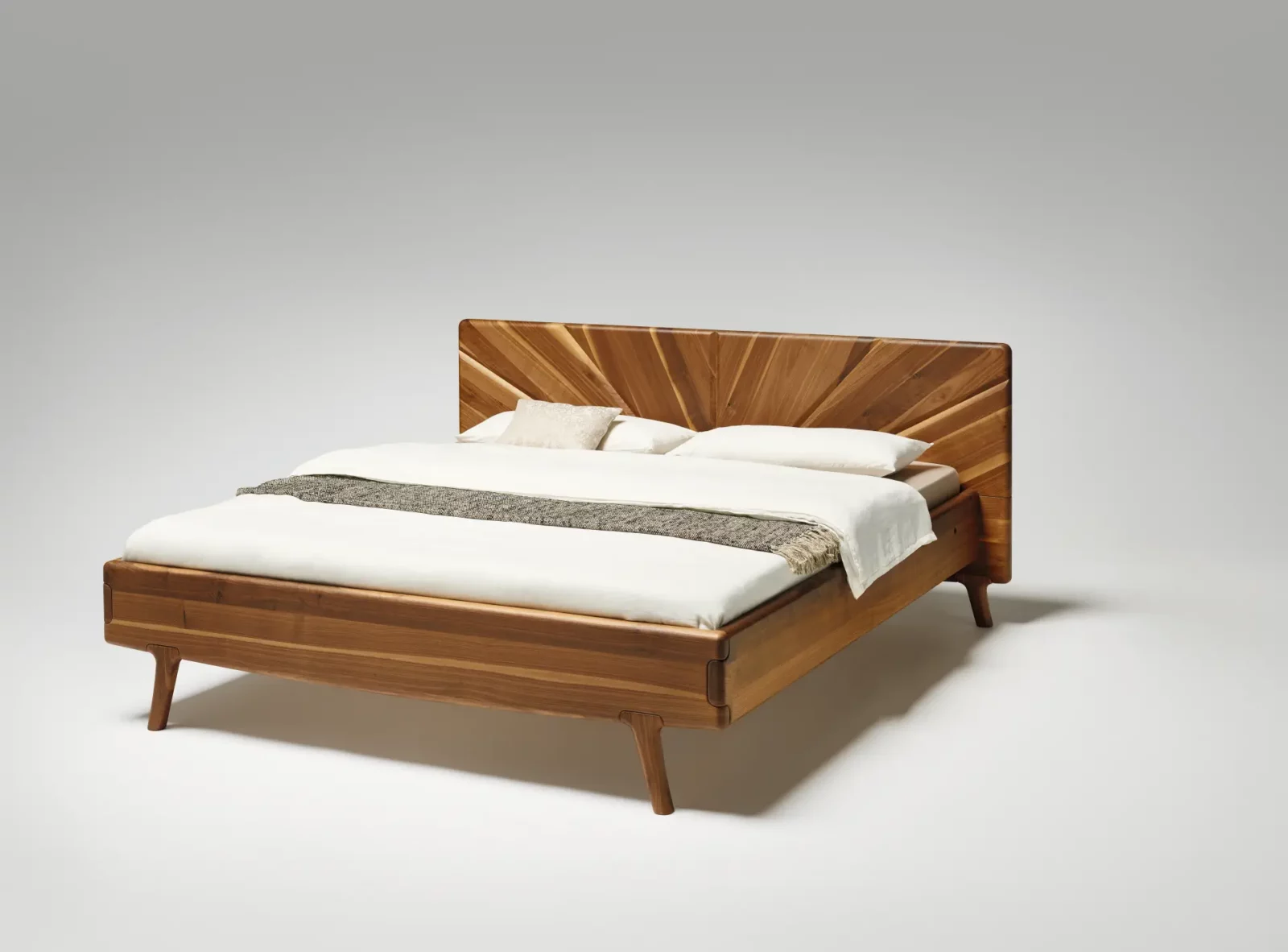 Anrei Sol Bett aus Holz mit markantem Kopfteil-Design.