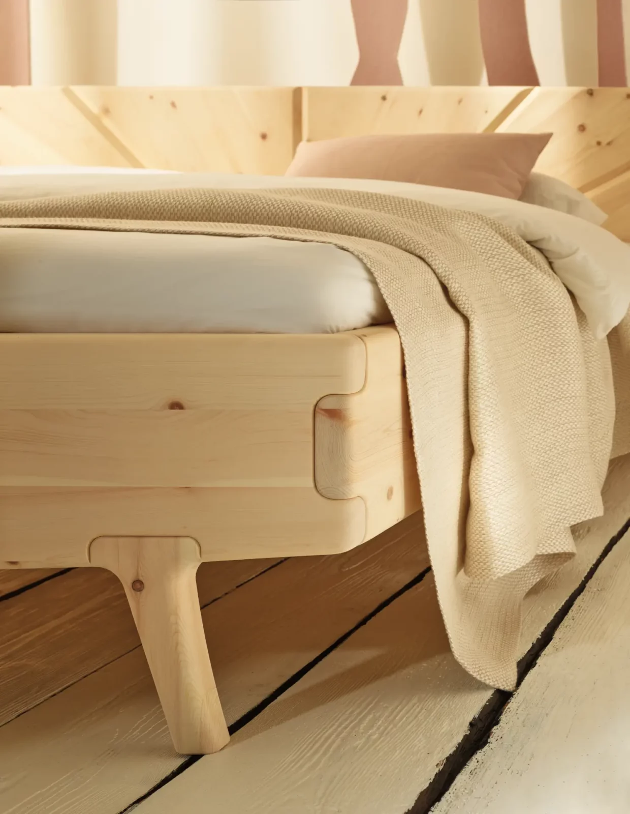 Anrei Sol Bett aus weiß geölter Zirbe mit markanter Holzstruktur.
