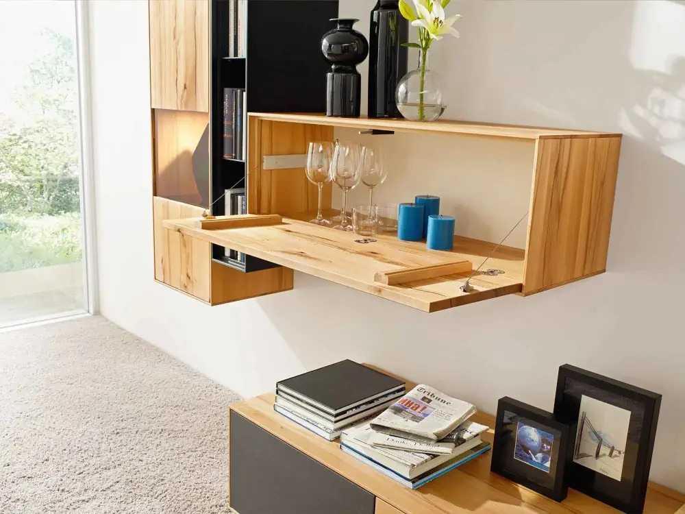 Wandregal aus Holz mit Klapptür, integriertem Stauraum und Dekoration.