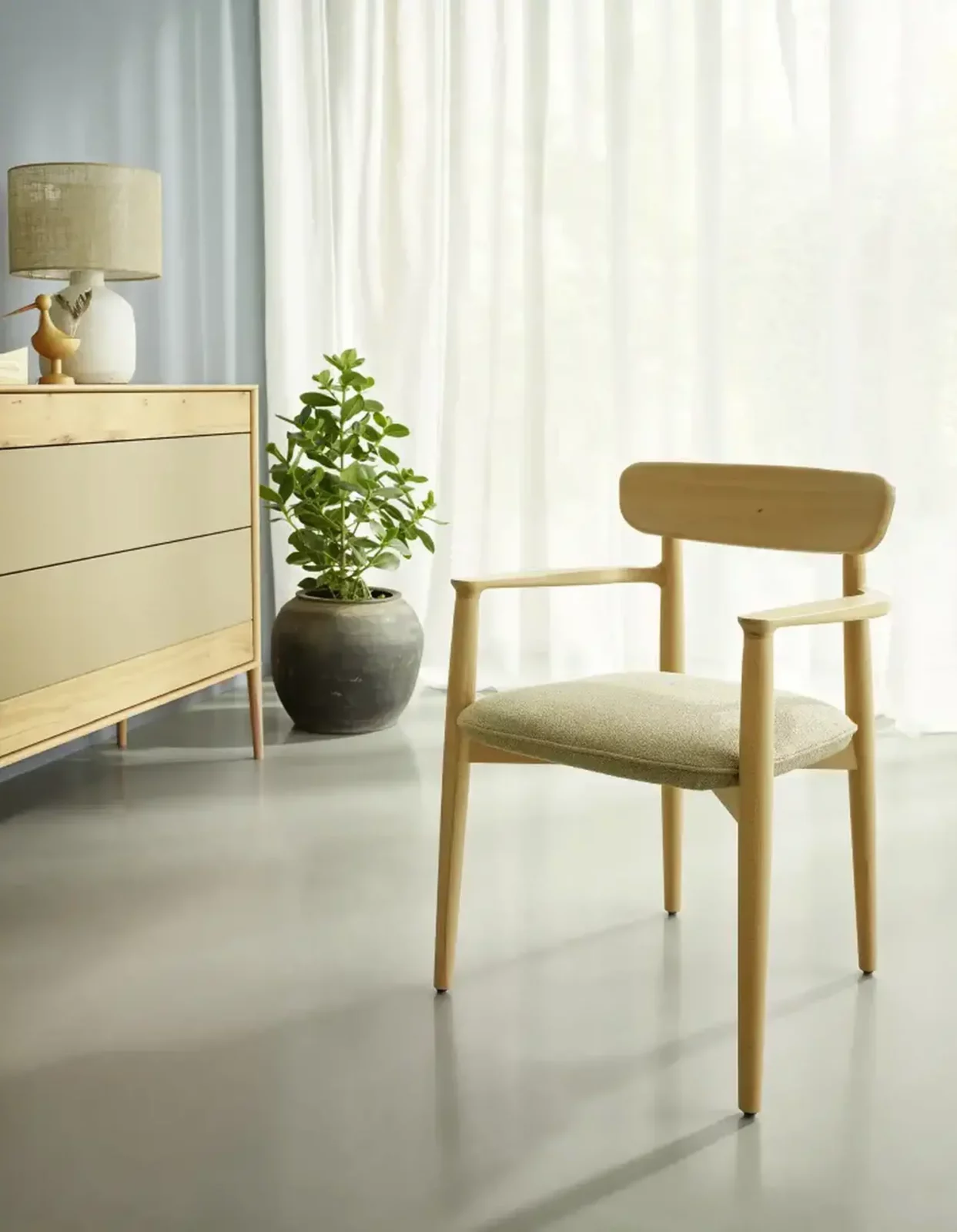 Anrei Juna Stuhl aus hellem Holz mit gepolstertem Sitz.