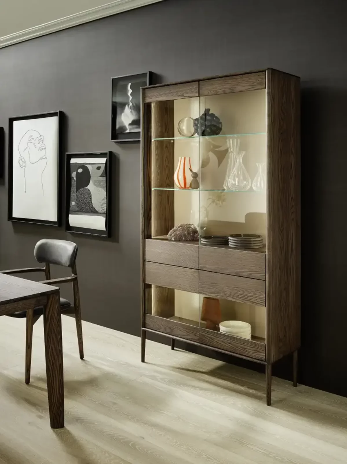 Anrei Juna Vitrine aus dunklem Holz mit Glastüren und Regalböden.