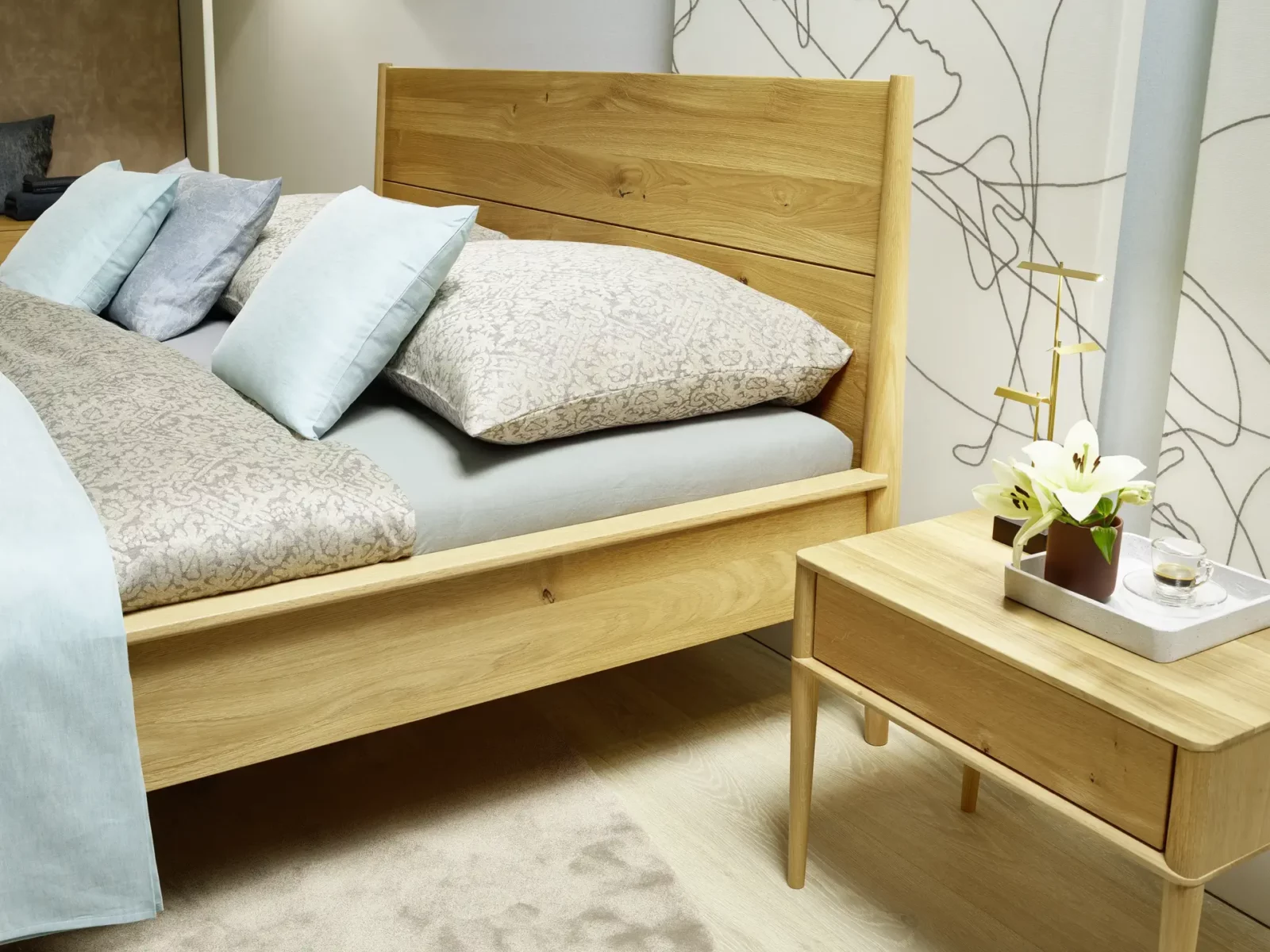 Anrei Juna Bett aus hellem Holz mit passendem Nachttisch.