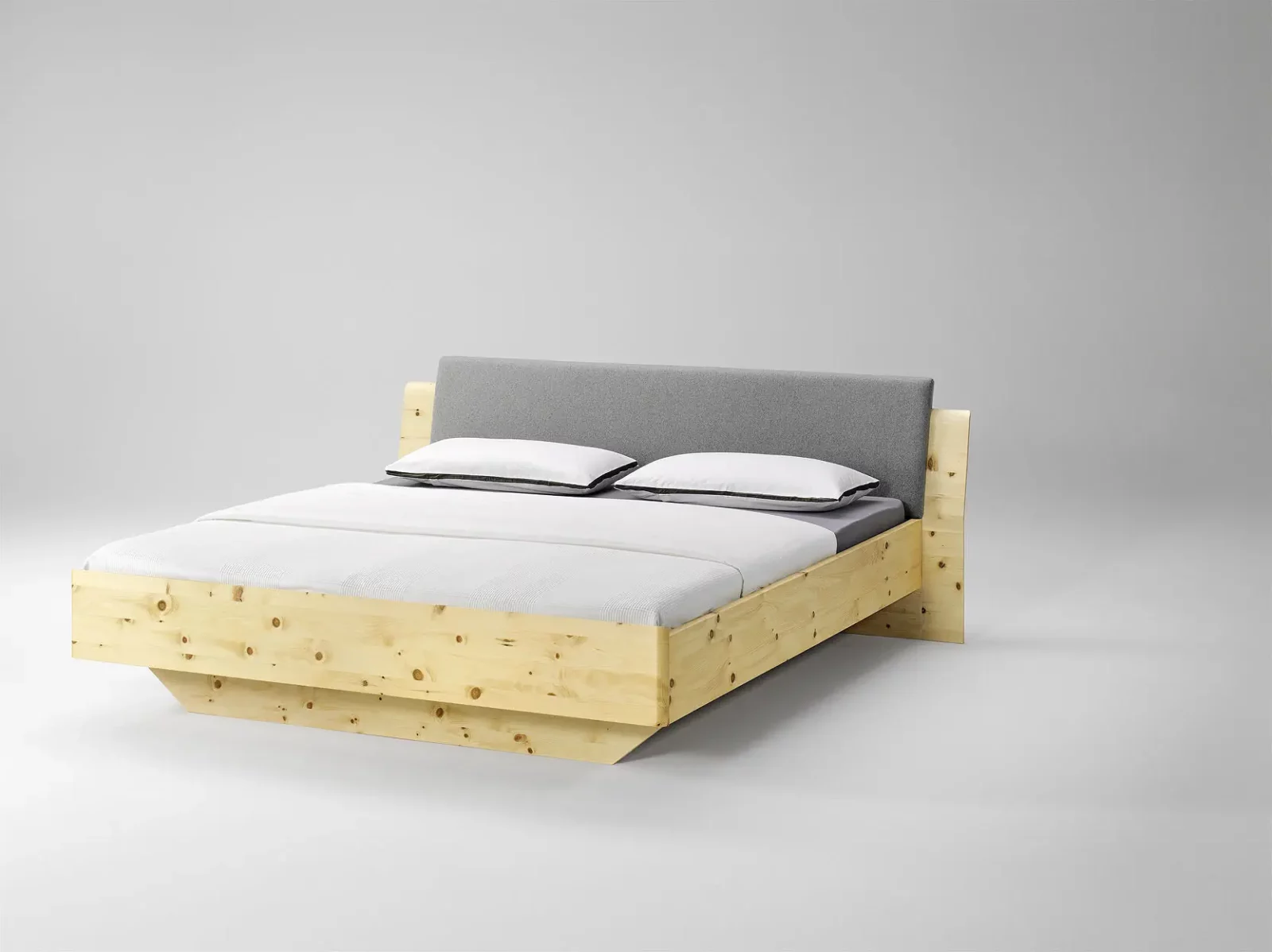 Anrei Tesso Bett aus Zirbenholz mit grauem Loden-Kopfteil.
