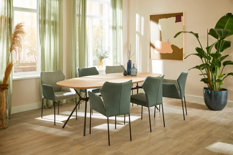 Ovale Freya Eettafel aus Eichenholz mit weißem Finish und grünen Stühlen.