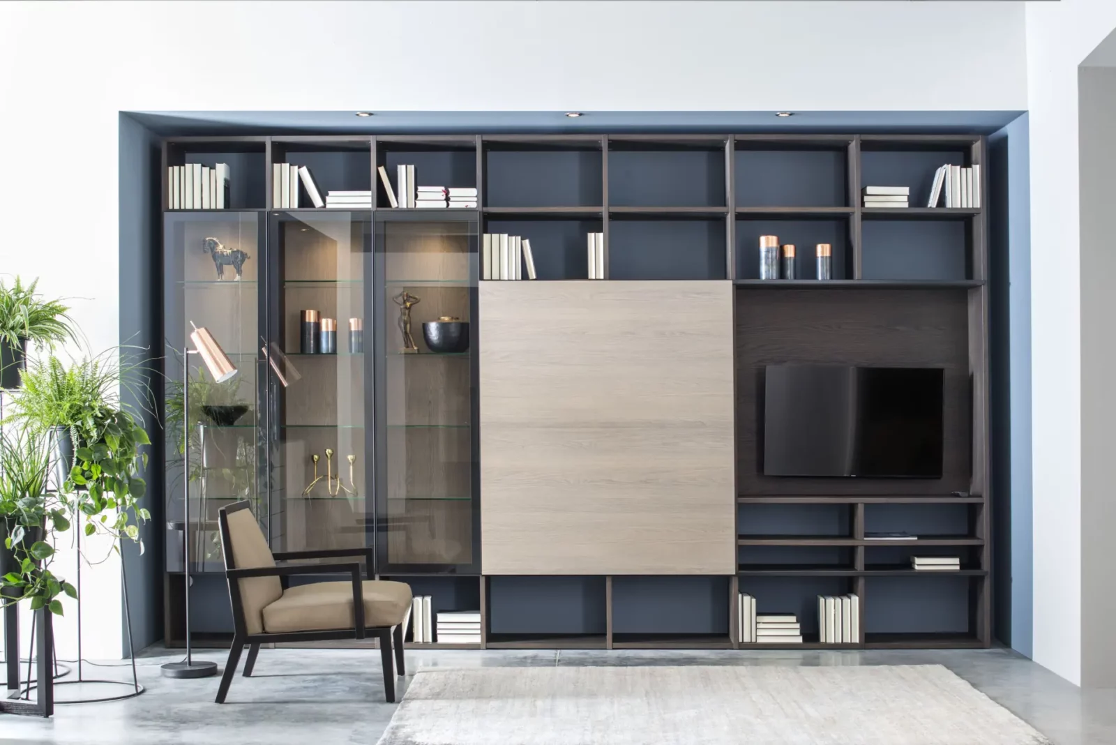 Fokos Wohnwand mit Glasvitrine, Holzoptik und integriertem TV-Bereich.