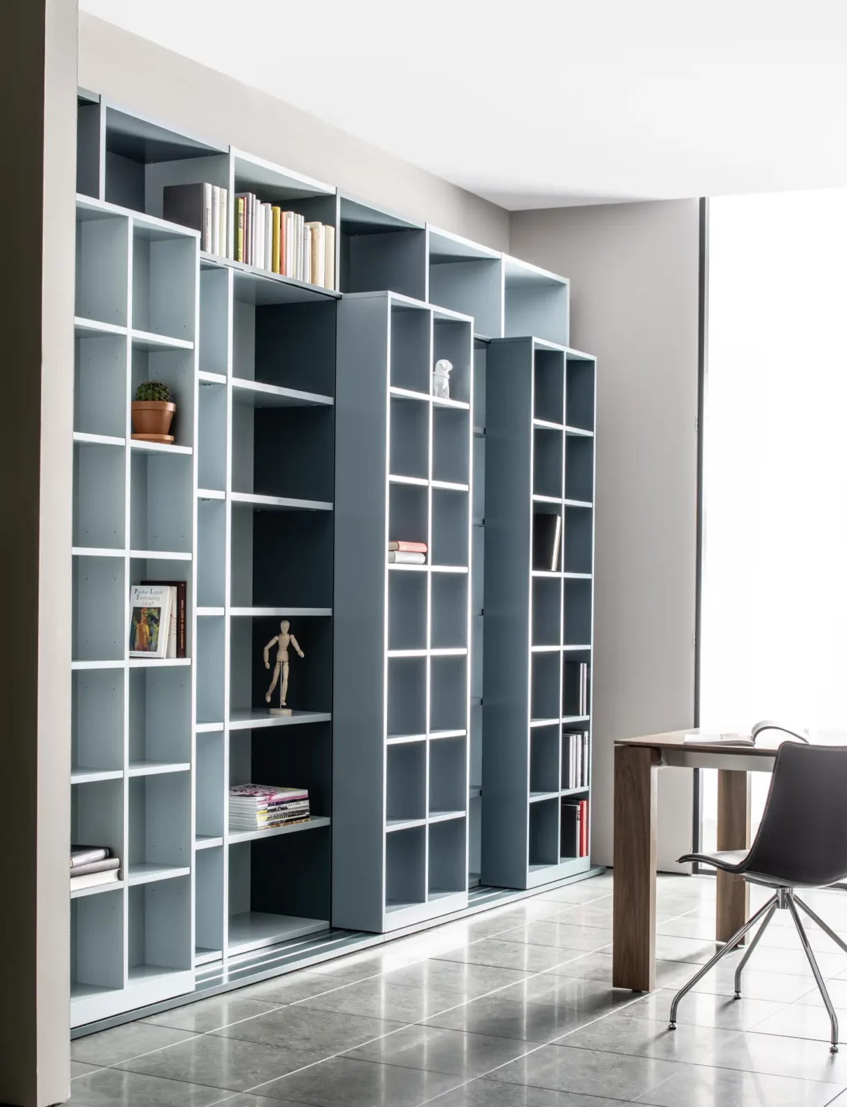 Regalwand Fokos 010 in Blau mit offenen Fächern und Bücheraufbewahrung.