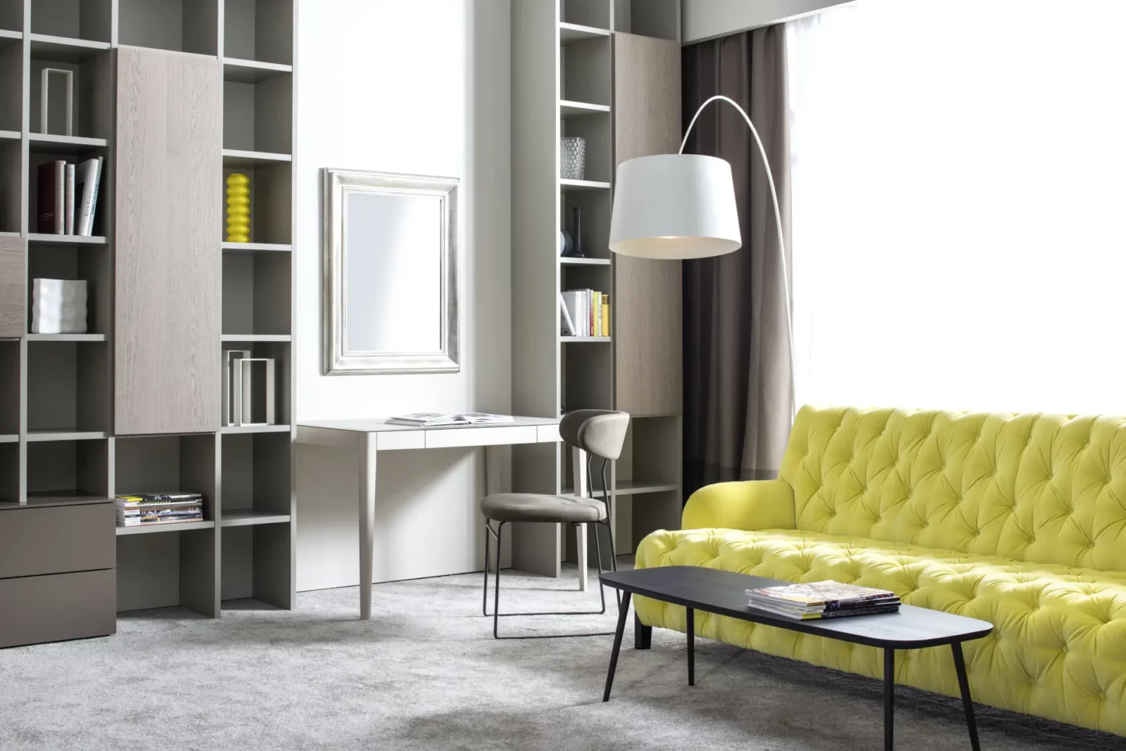Gelbes Sofa mit Knopfheftung, schwarzem Tisch und grauem Teppich.