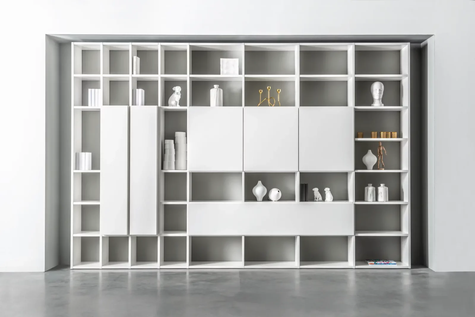 Weiße Regalwand mit asymmetrischen Fächern und Schrankelementen, Modell Fokos.