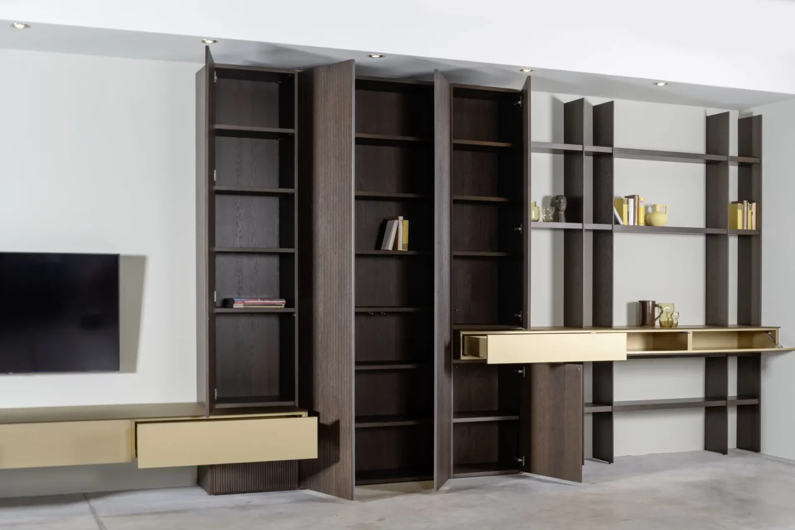 Hochwertiges Regal- und Schranksystem aus dunklem Holz mit goldenen Akzenten.
