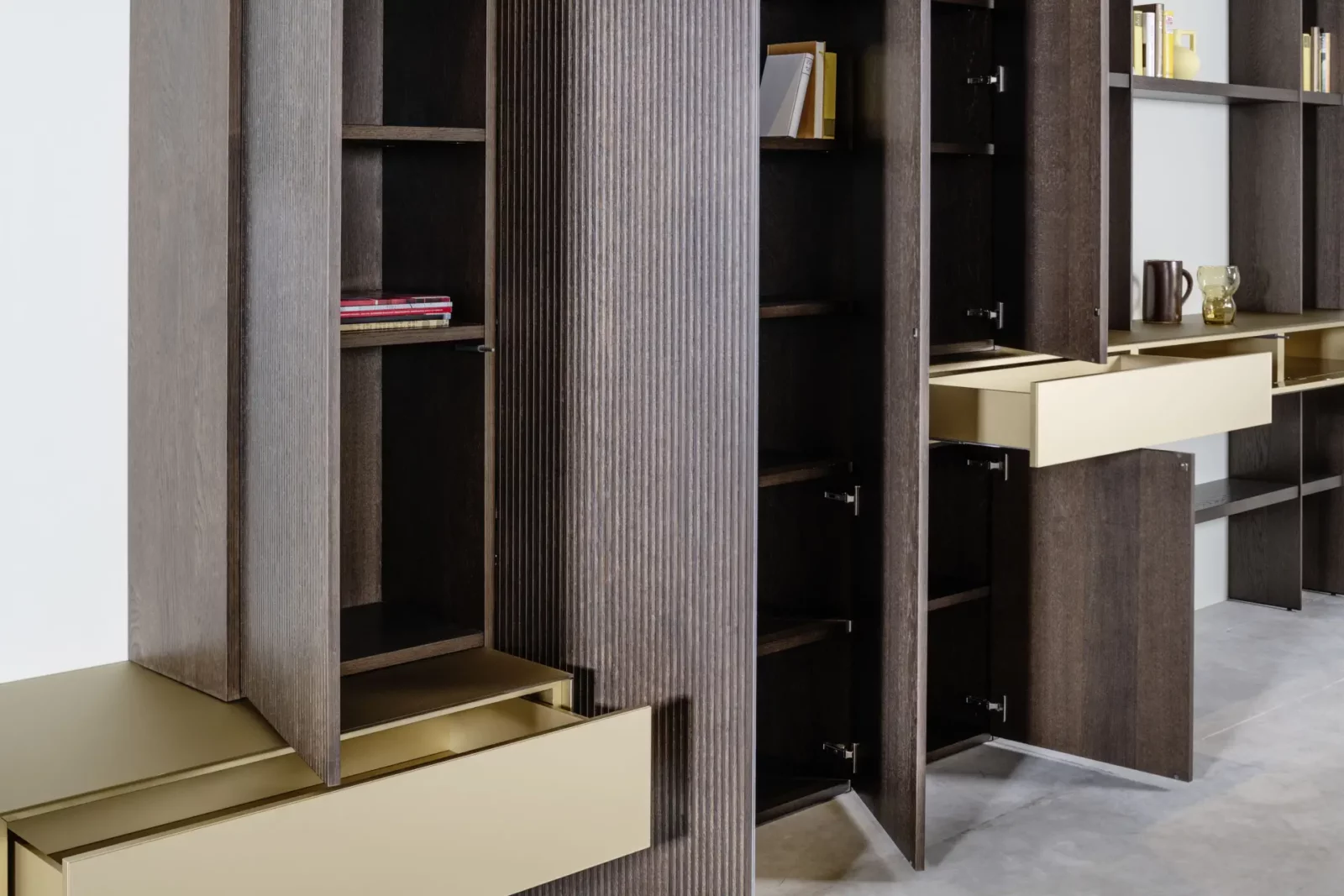 Hochwertiges Regalsystem Fokos 032 in dunklem Holz mit goldenen Schubladen.