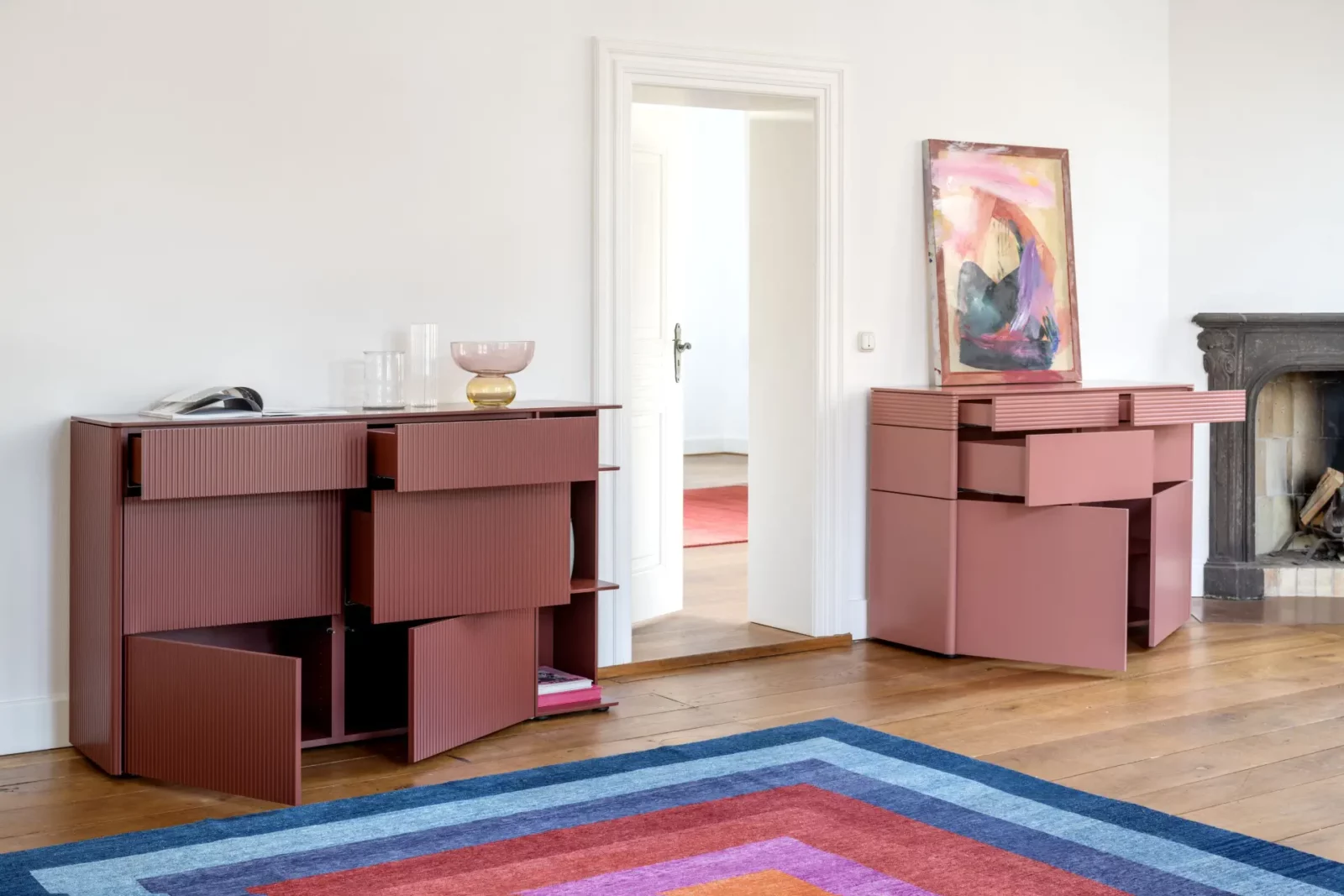 Sideboard Gaya in Rosa mit gerillten Fronten und offenen Schubladen.