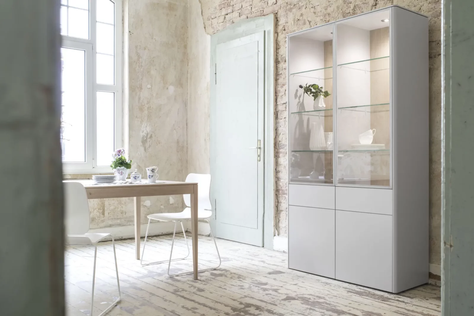 Vitrine Gaya 009, weiß, mit Glastüren und Holzdetails.