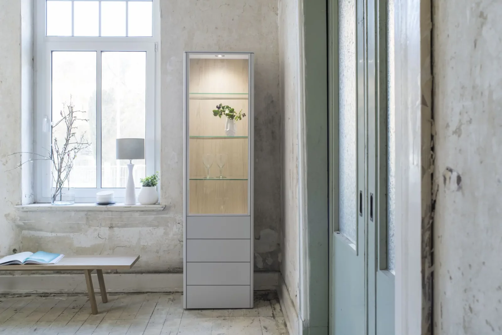 Vitrine Gaya 033, Glasfront, Holzoptik, graue Schubladen, integrierte Beleuchtung.