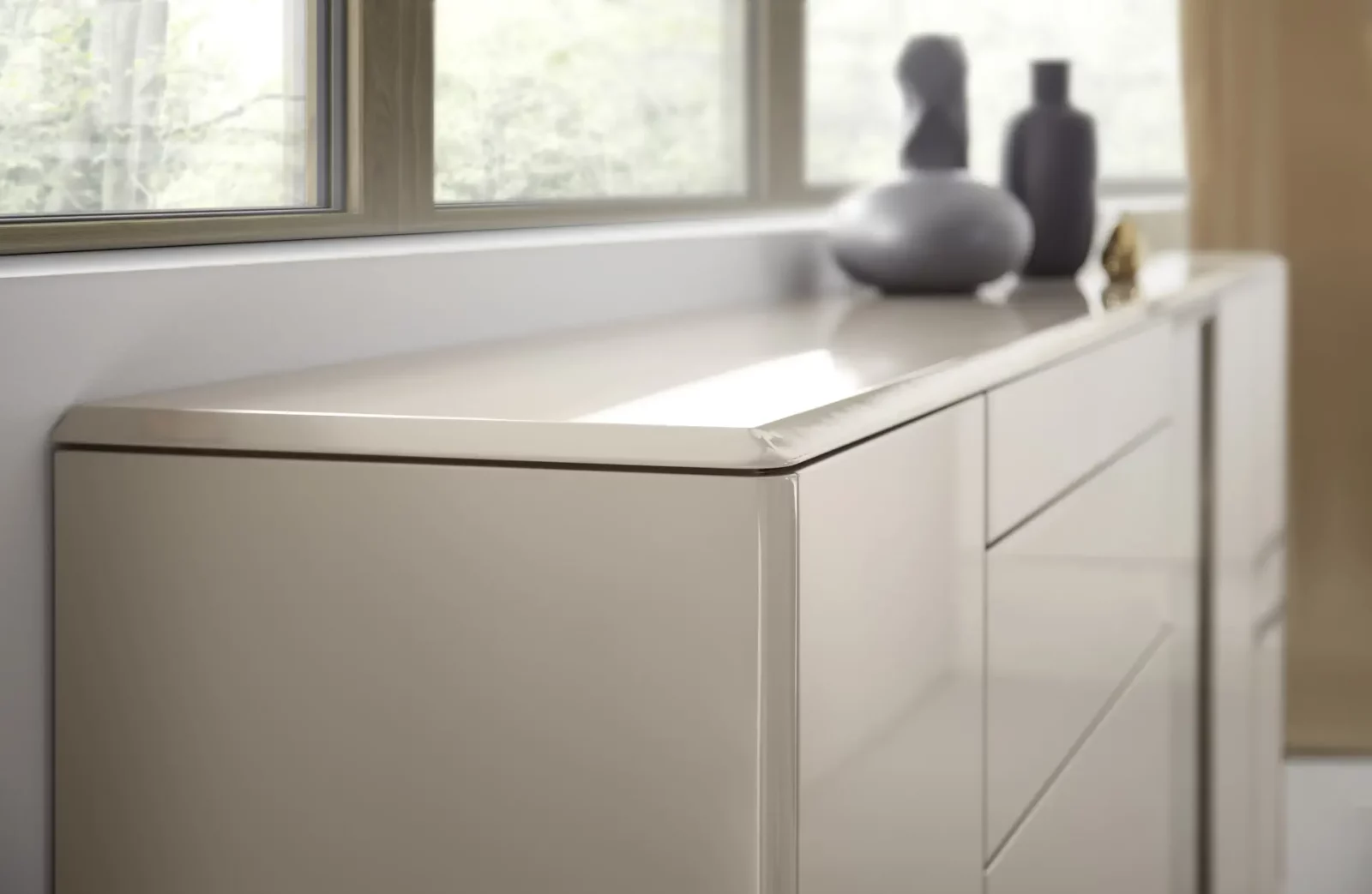 Kommode Gaya in Hochglanz Beige mit abgerundeten Kanten und Schubladen.