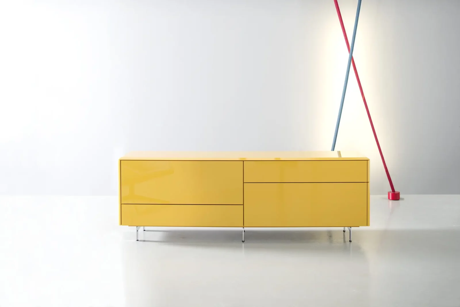Sideboard Gaya in glänzendem Gelb mit minimalistischen Metallfüßen.