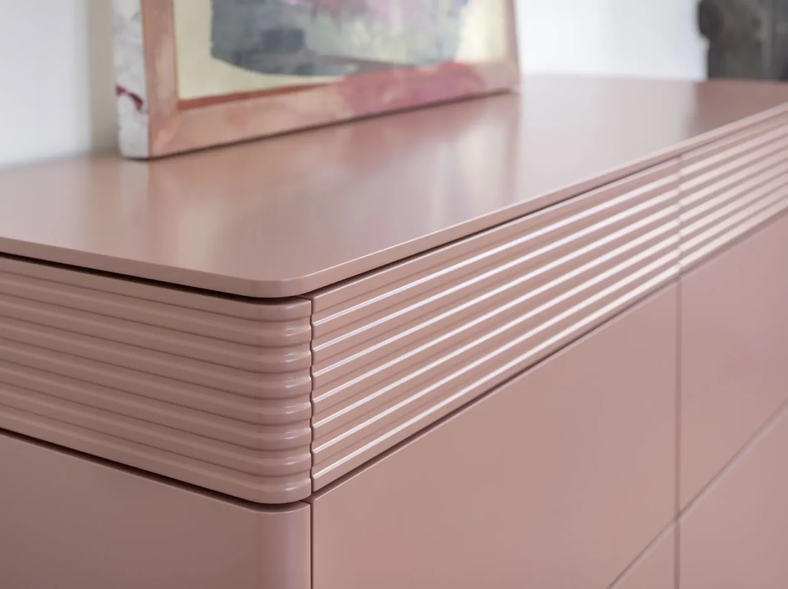 Kommode Gaya 103 in Rosa mit gerillten Fronten und glatter Oberfläche.