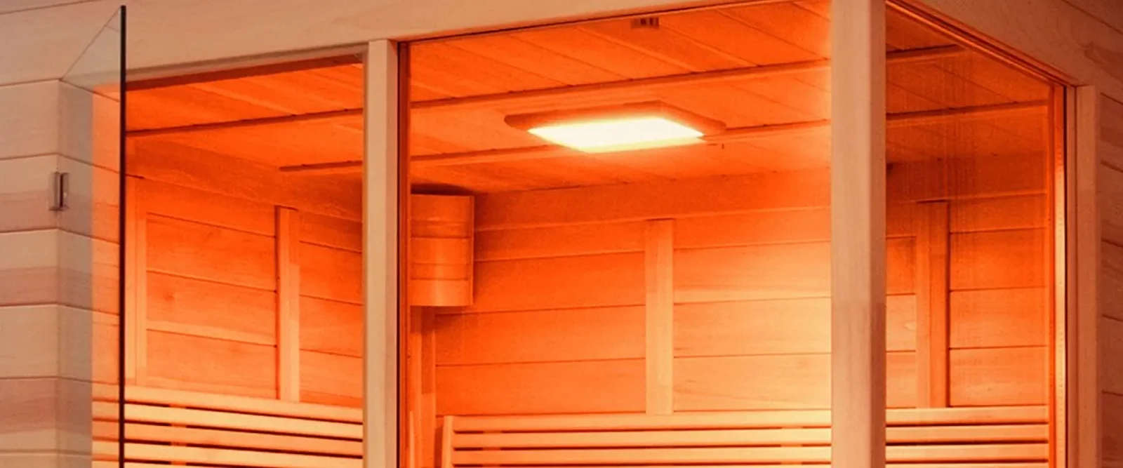Infrarotkabine mit orangefarbenem Farblicht, Holzverkleidung und Glastür.