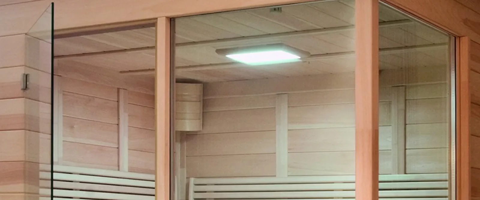 Infrarotkabine aus hellem Holz mit Glastür und integrierter Beleuchtung.