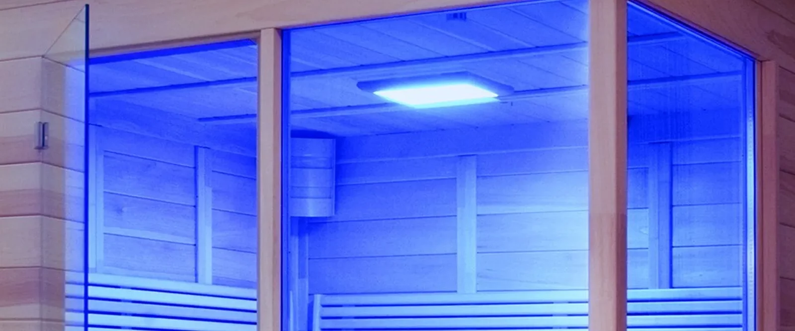 Infrarotkabine mit blauer Farblichtbeleuchtung, Holzverkleidung und Glasfront.