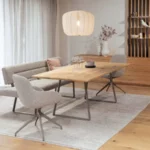 Ein elegantes Esszimmer mit einem massiven Holztisch, hellen Bouclé-Stühlen und einer passenden Sitzbank auf einem modernen, hellen Teppich.