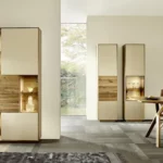 Elegante Wohnzimmer-Vitrinenschränke aus hellem Holz und cremefarbenen Fronten mit stimmungsvoller Innenbeleuchtung in einem modernen Essbereich.