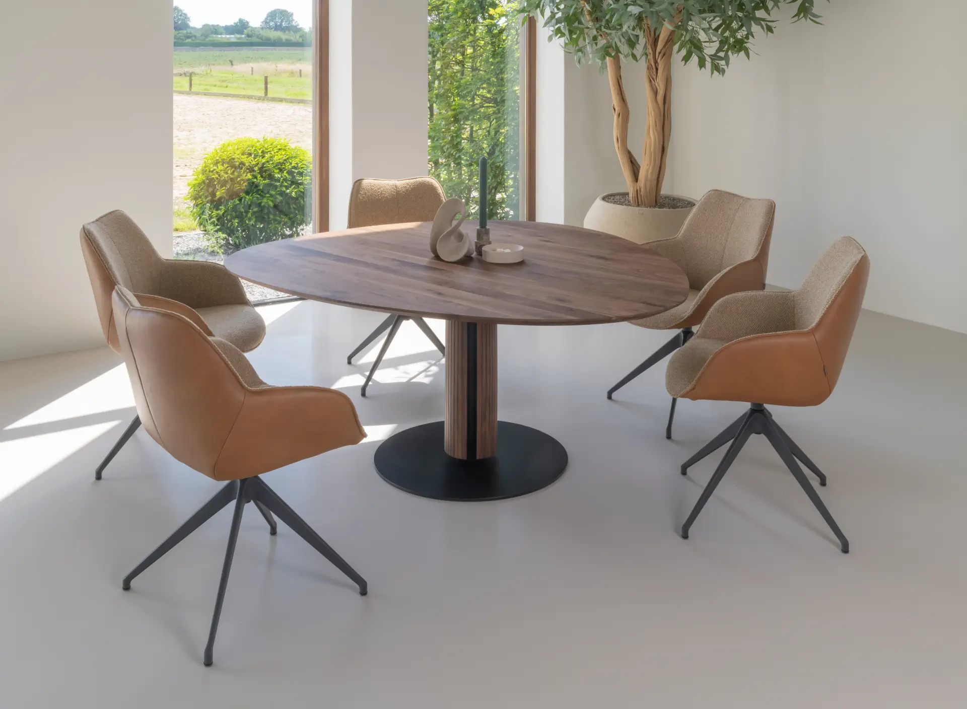 Kiq Steely XL Esstisch aus massivem Nussbaum mit cognacfarbenen Stühlen.
