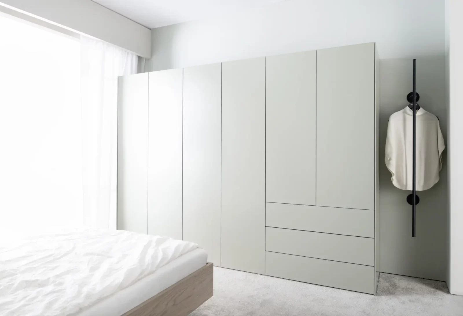 Großer, weißer Einbauschrank mit glatten Fronten und integrierten Schubladen.