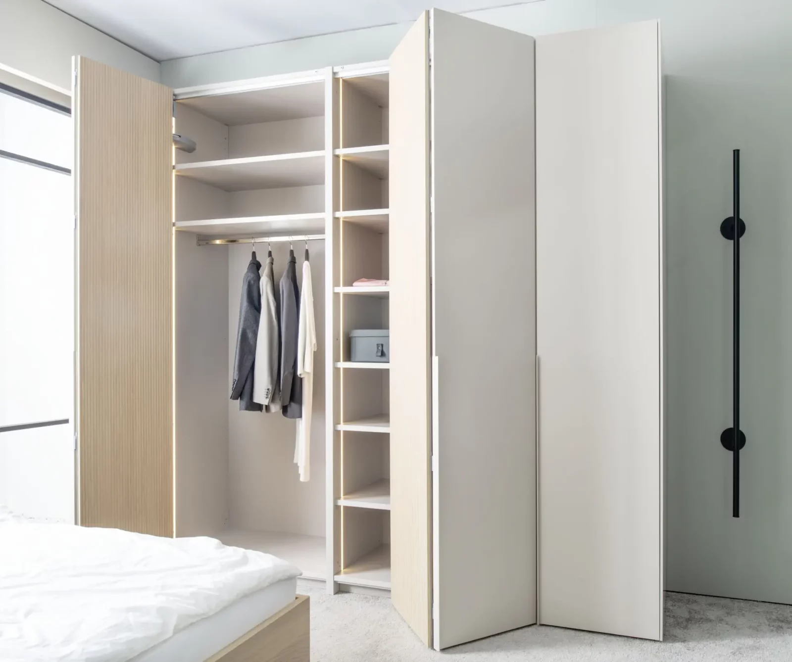 Eckkleiderschrank Maria 024 mit Falttüren, helle Holzausführung, integrierte Regale.
