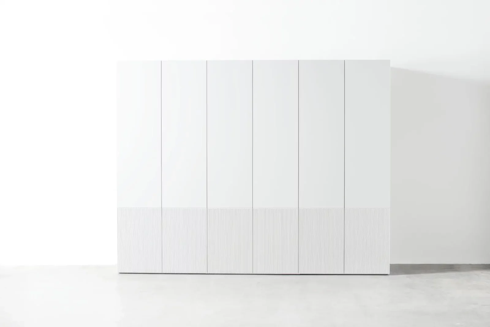 Weißer Kleiderschrank "Maria 034" mit glatter Oberfläche und geriffeltem Sockel.