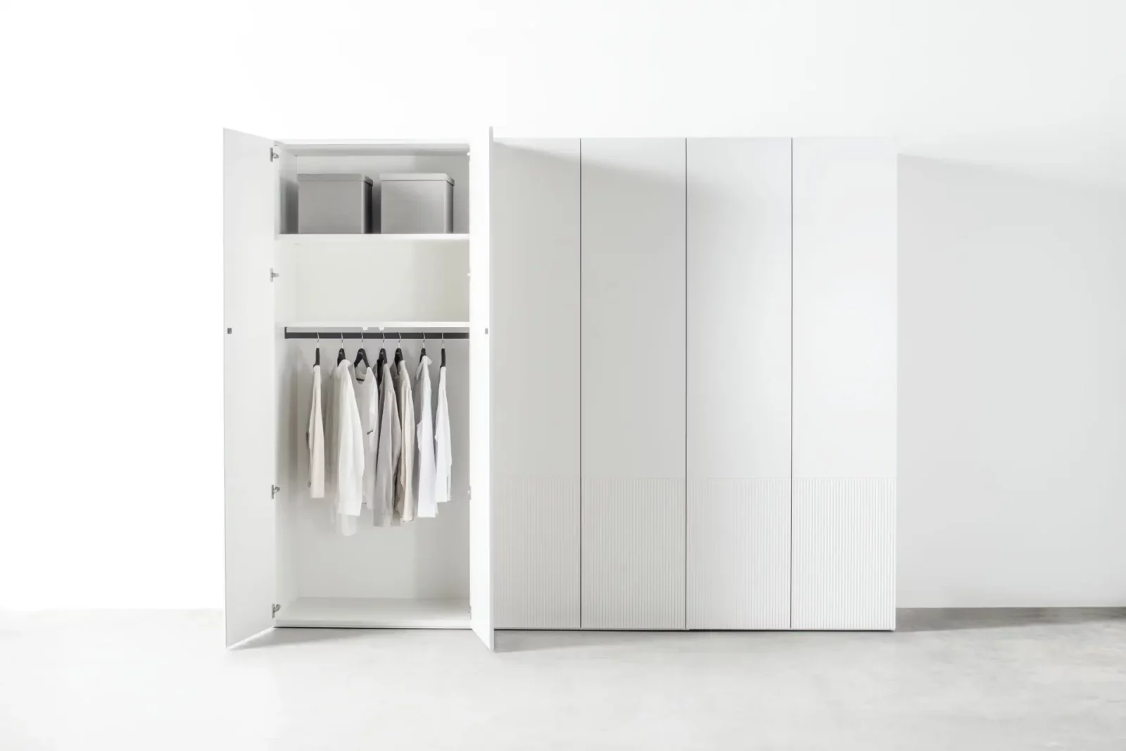Weißer Kleiderschrank mit offenen Türen, Innenraum mit Kleiderstange und Ablage.