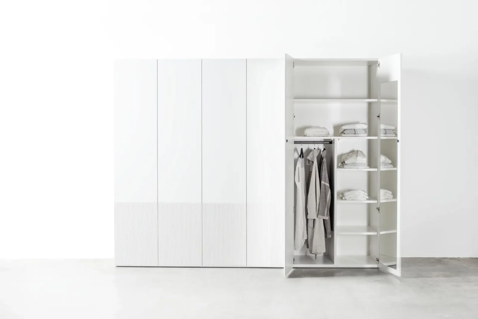 Weißer Kleiderschrank "Maria 039" mit offenen und geschlossenen Türen.