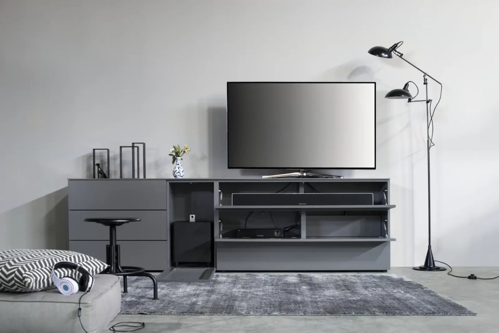 Graues TV-Möbelstück Nubo 004 mit offenen Fächern und Schubladen.