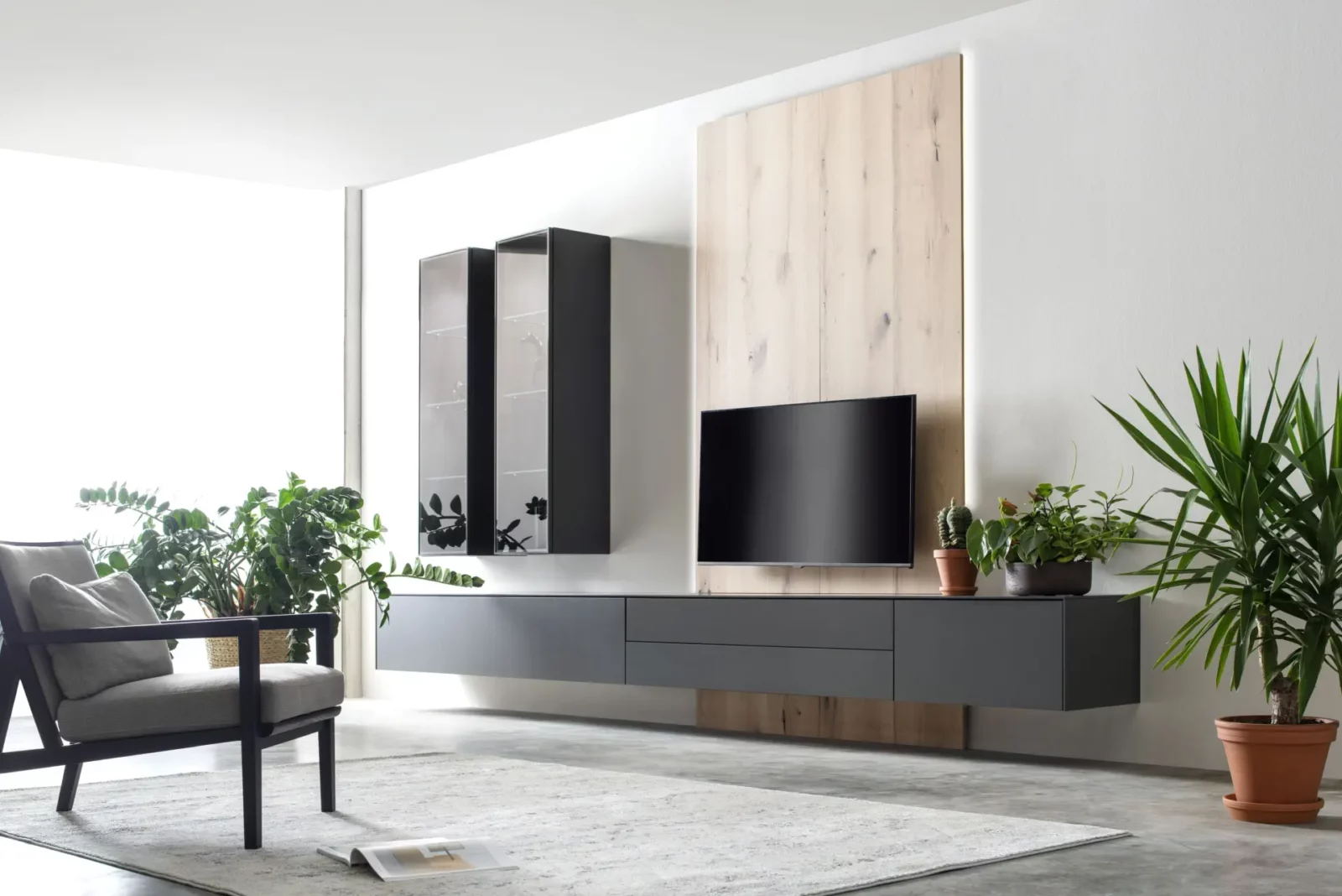 Nubo 037 Wohnwand in dunkler Ausführung mit hängenden Schränken und TV.
