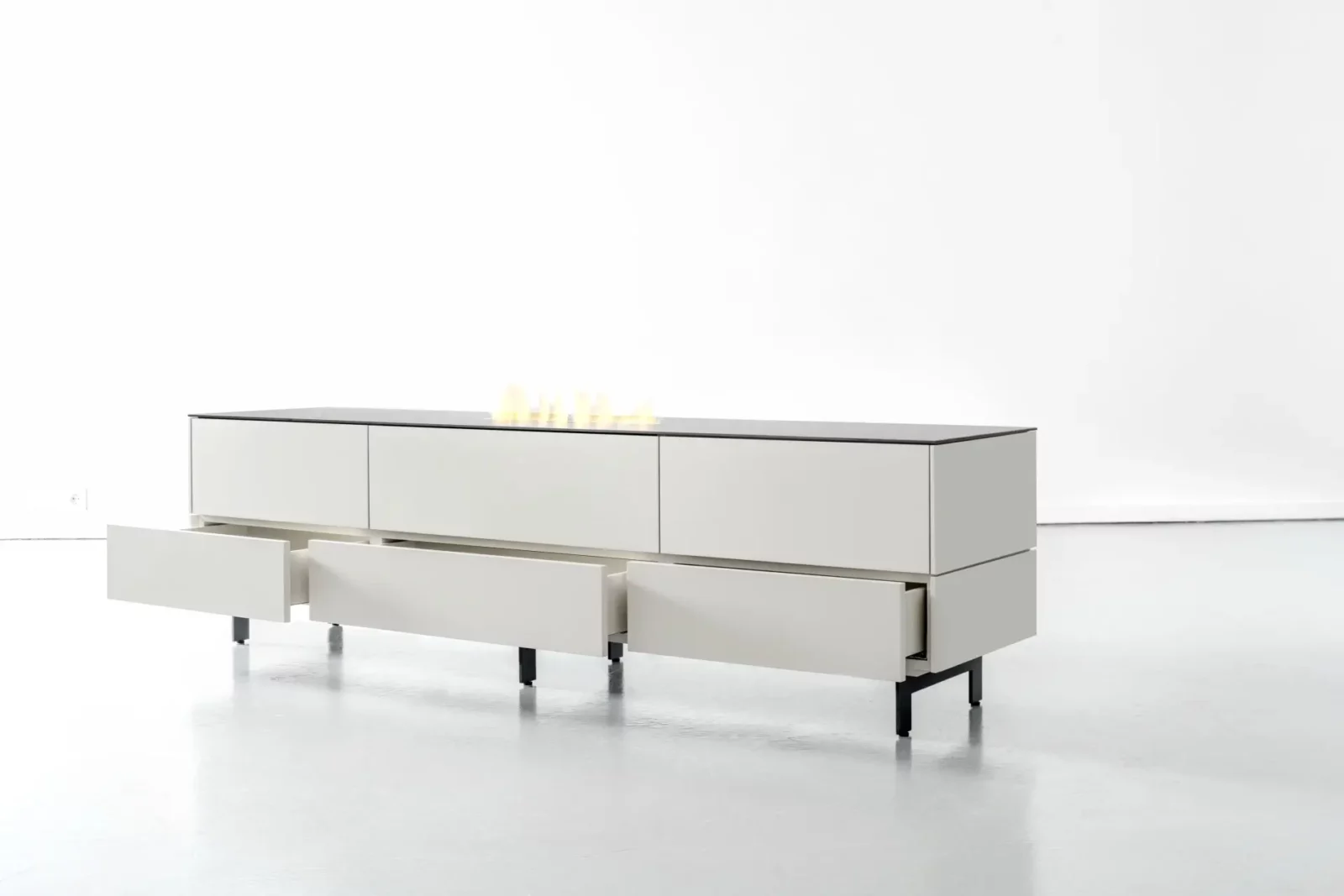Sideboard Nubo 096 in Weiß mit schwarzen Beinen und offenen Schubladen.