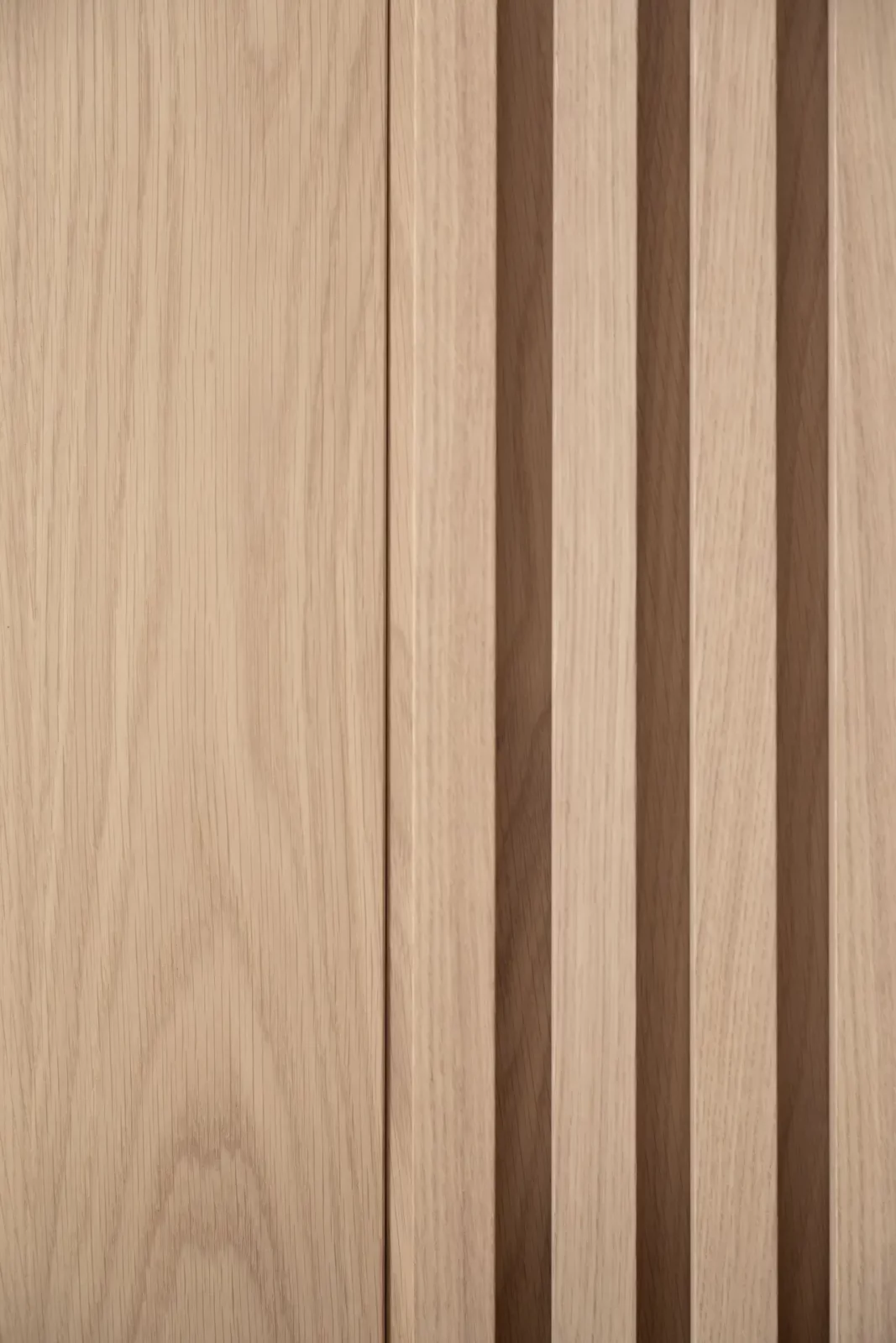 Nubo 148 Wandverkleidung aus hellem Holz mit vertikalen Lamellen.