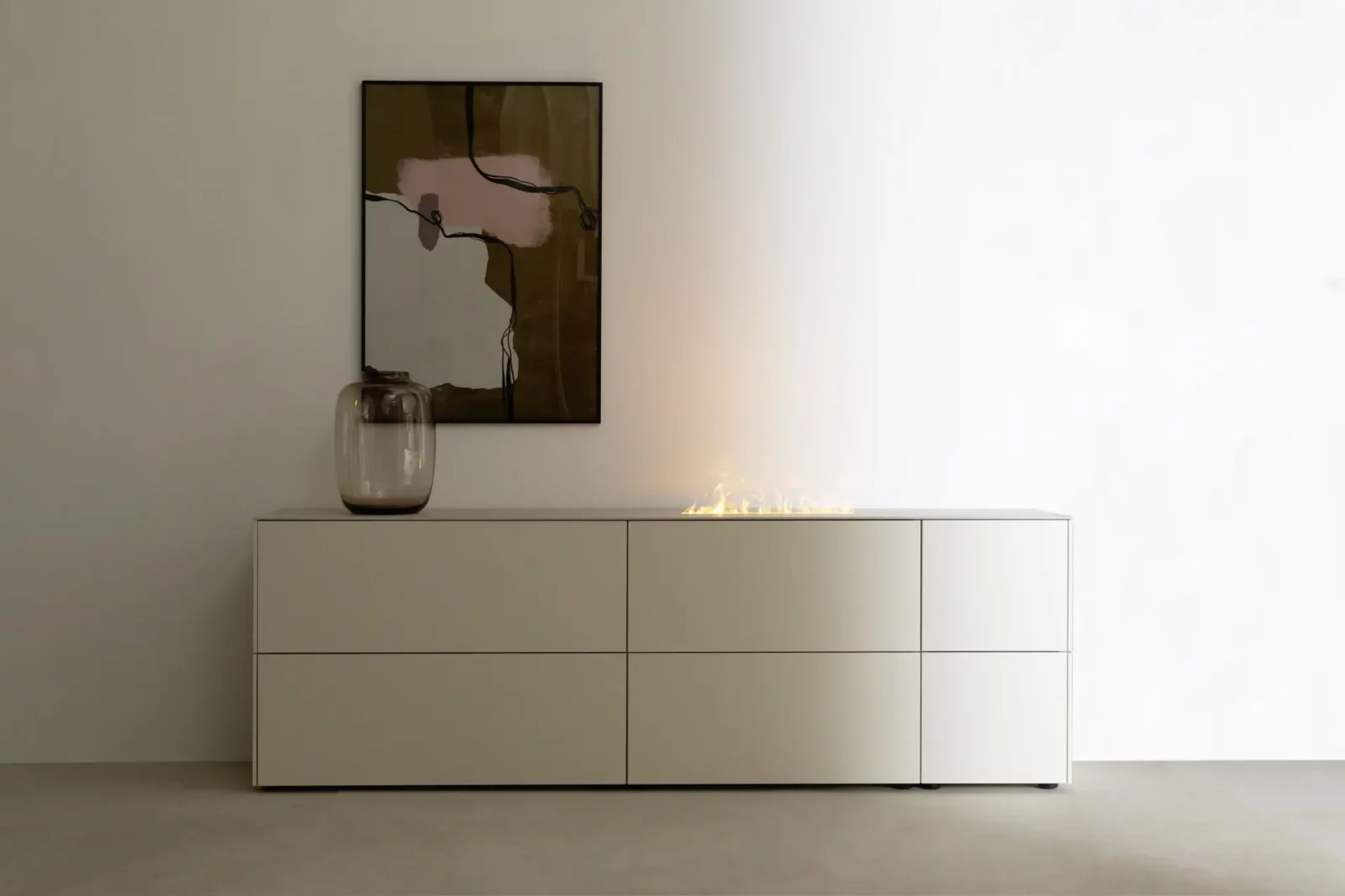 Sideboard Nubo 156 in cremeweiß mit integriertem Kamin und sechs Schubladen.