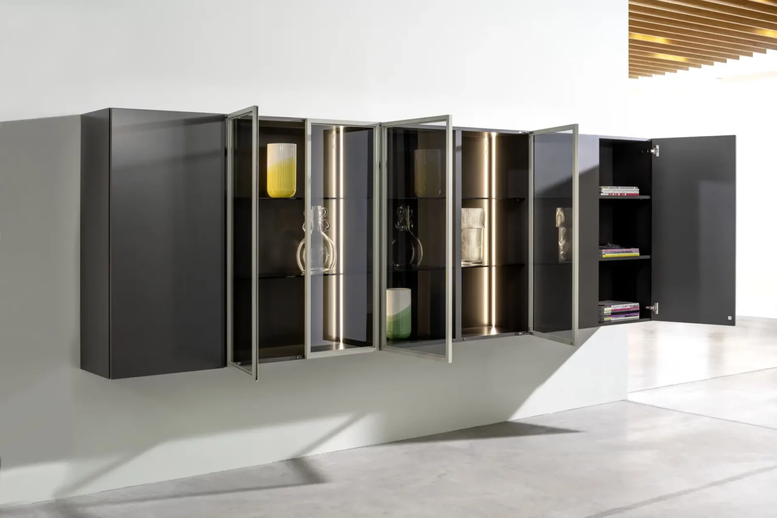 Hochwertiges Wandregal Nubo 189 mit Glasfronten und dunklem Holzfinish.