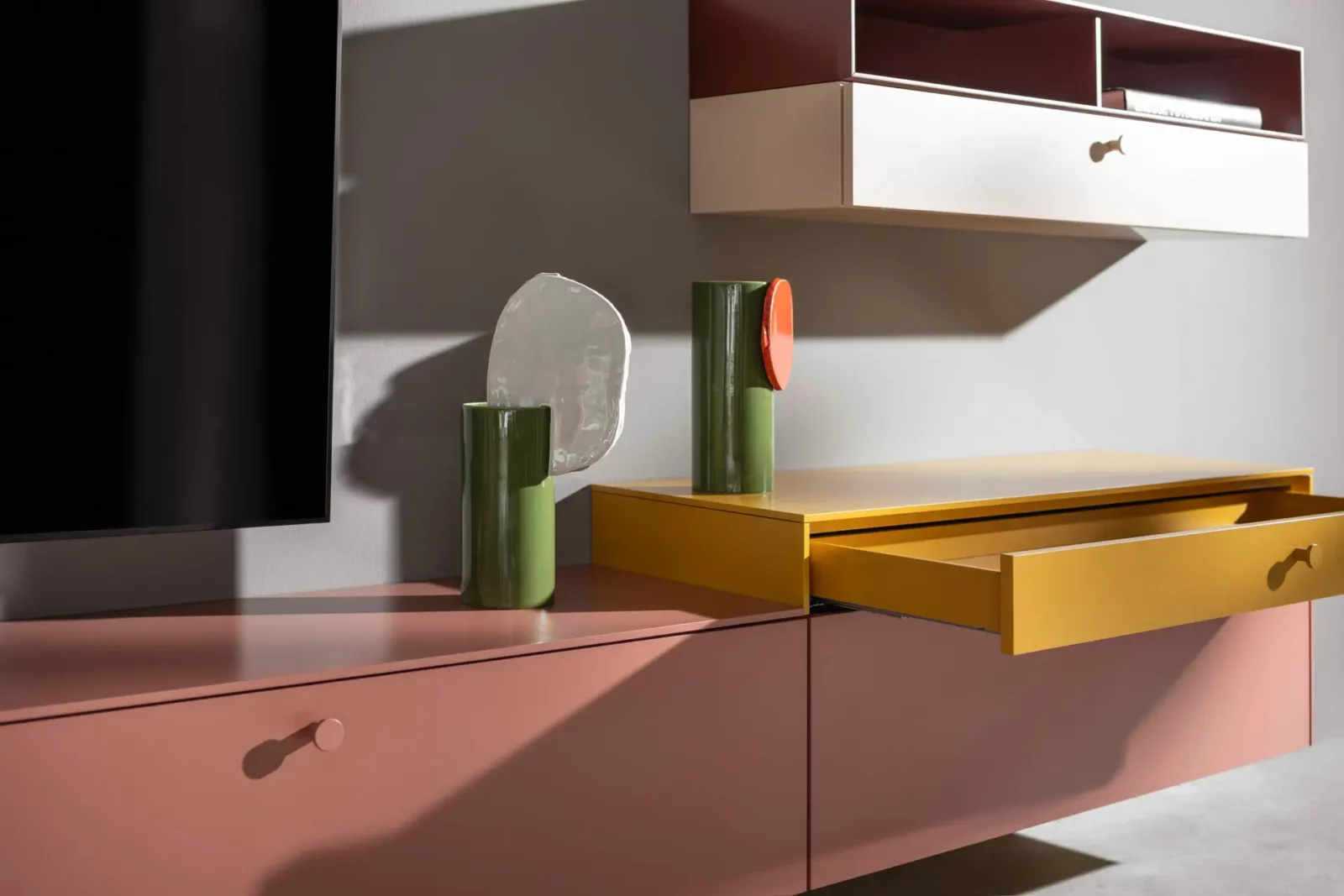 Sideboard Nubo 196 in Rosa und Gelb mit offenen Schubladen.