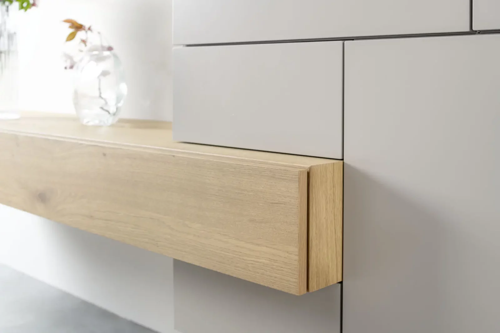 Sideboard Nubo 214 mit Eichenholzfront und grauen Schubladen.
