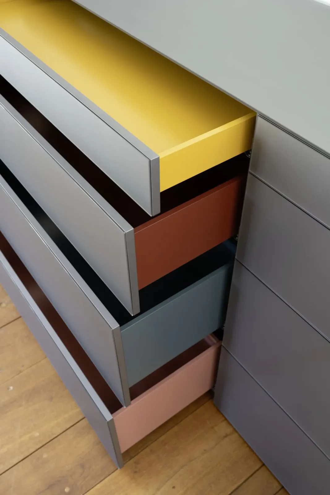 Kommode Nubo 251 mit farbigen Schubladen in Grau, Gelb, Braun, Blau und Rosa.
