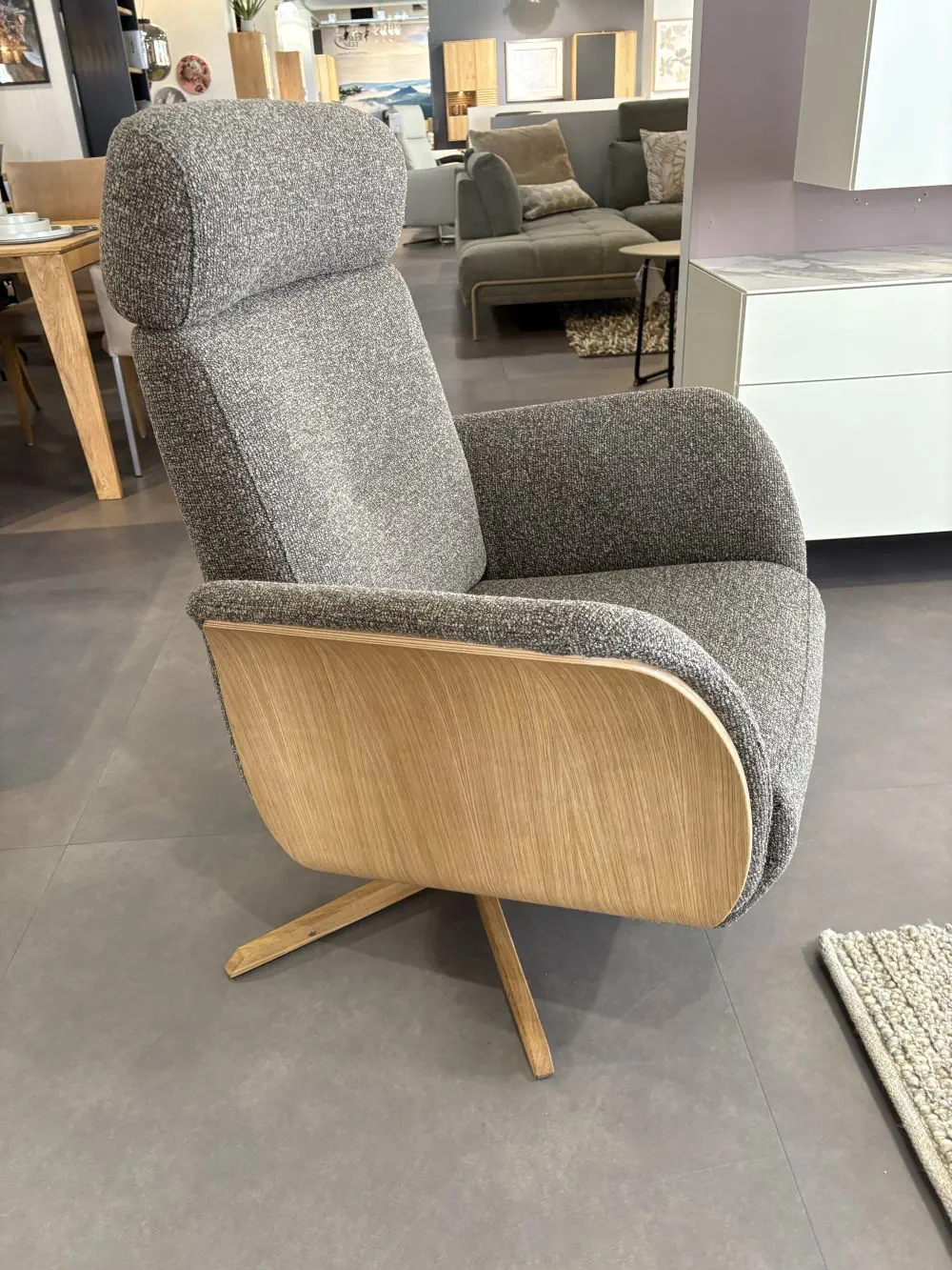 Relaxsessel Rito 02 mit grauem Stoffbezug und Holzdetails.