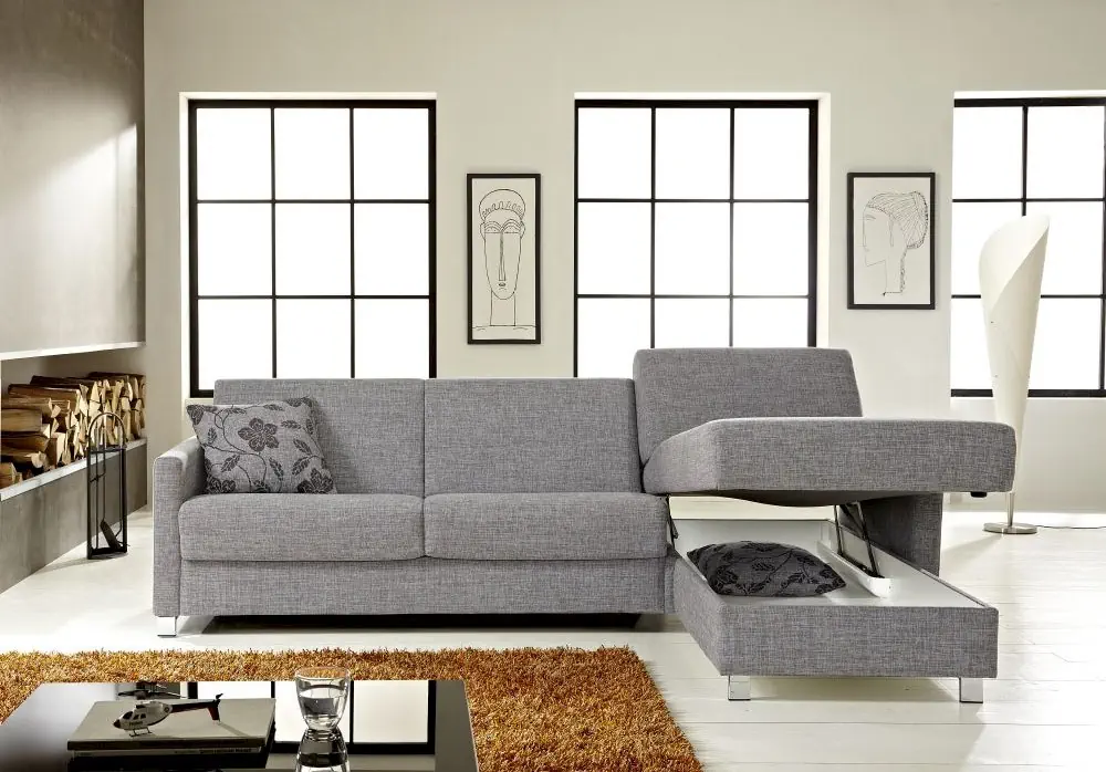 Schlafsofa Messida in grauem Stoff mit ausziehbarem Bettkasten.