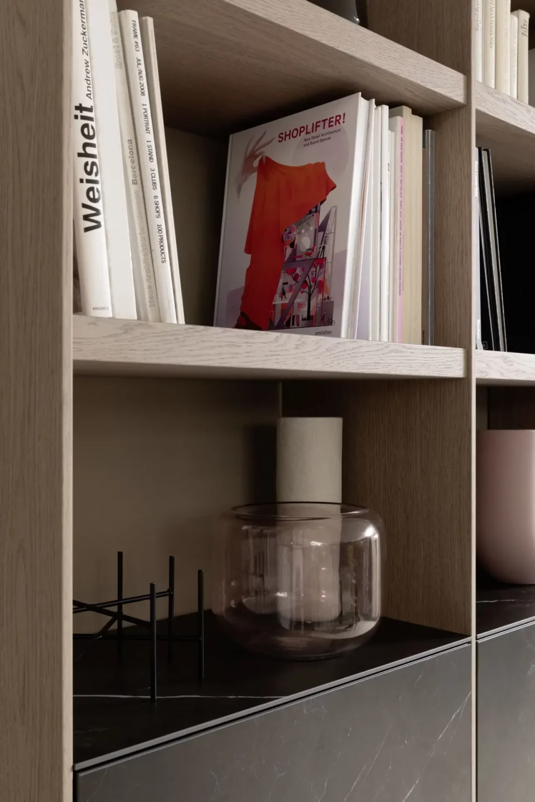 Regal Scalo 021 aus hellem Holz mit Bücherablage und Dekoration.