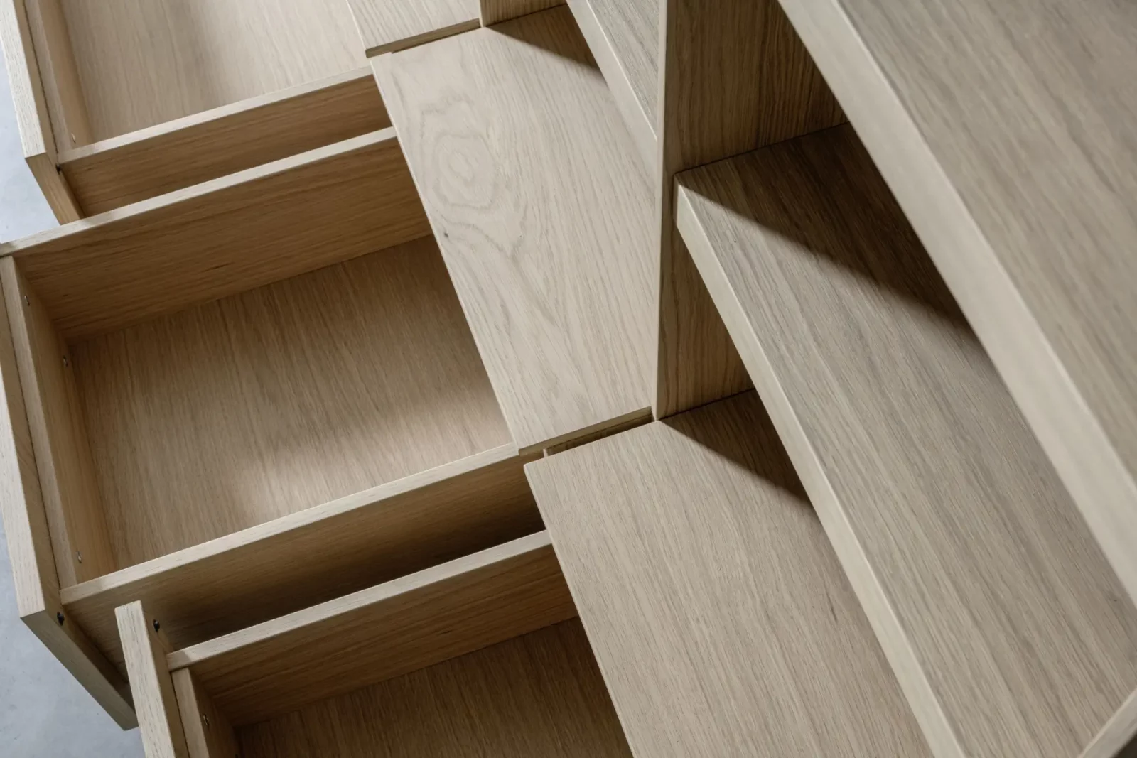 Regal Scalo 023 aus hellem Holz mit offenen Fächern.