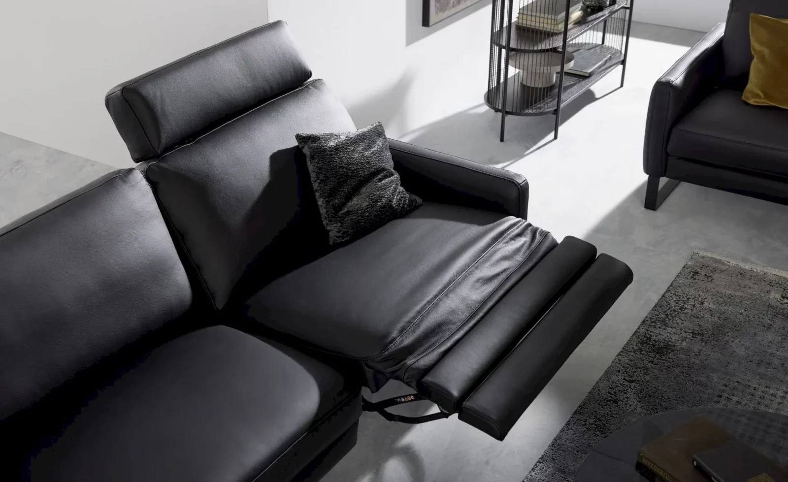 Sofa Giovanna in schwarzem Leder mit verstellbarer Fußstütze.